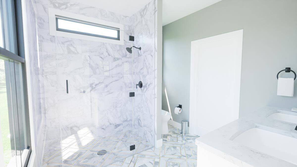 Primary bathroom with a dual sink vanity and a tiled shower brightened by a clerestory window.