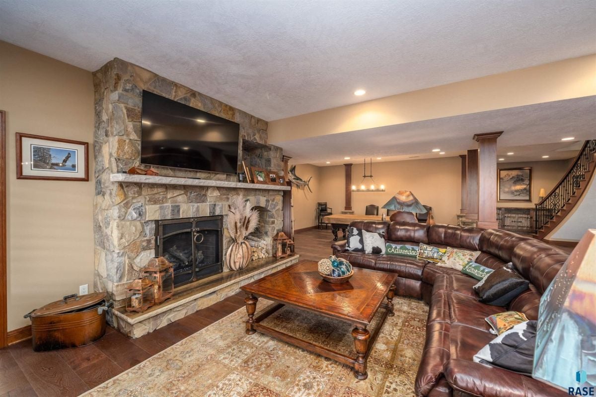 Living room with couches, custom lighting and a fireplace.