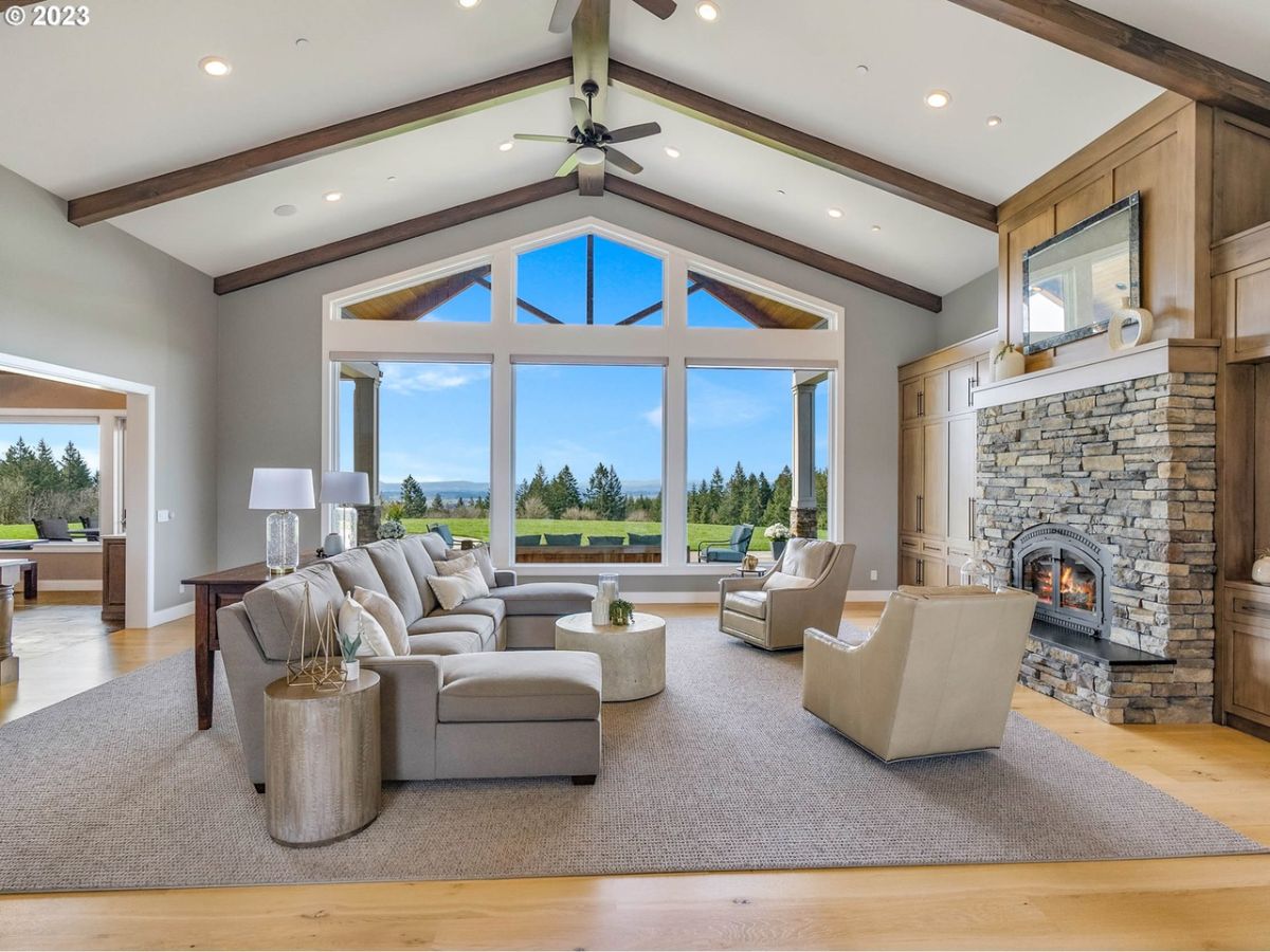 Living room with couches, a fireplace and large glass windows.