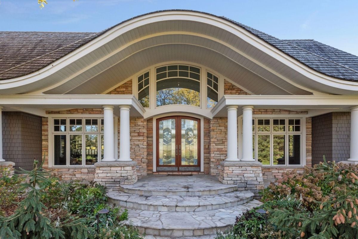 Formal entry of the house with a stone front porch and a stone walkway.