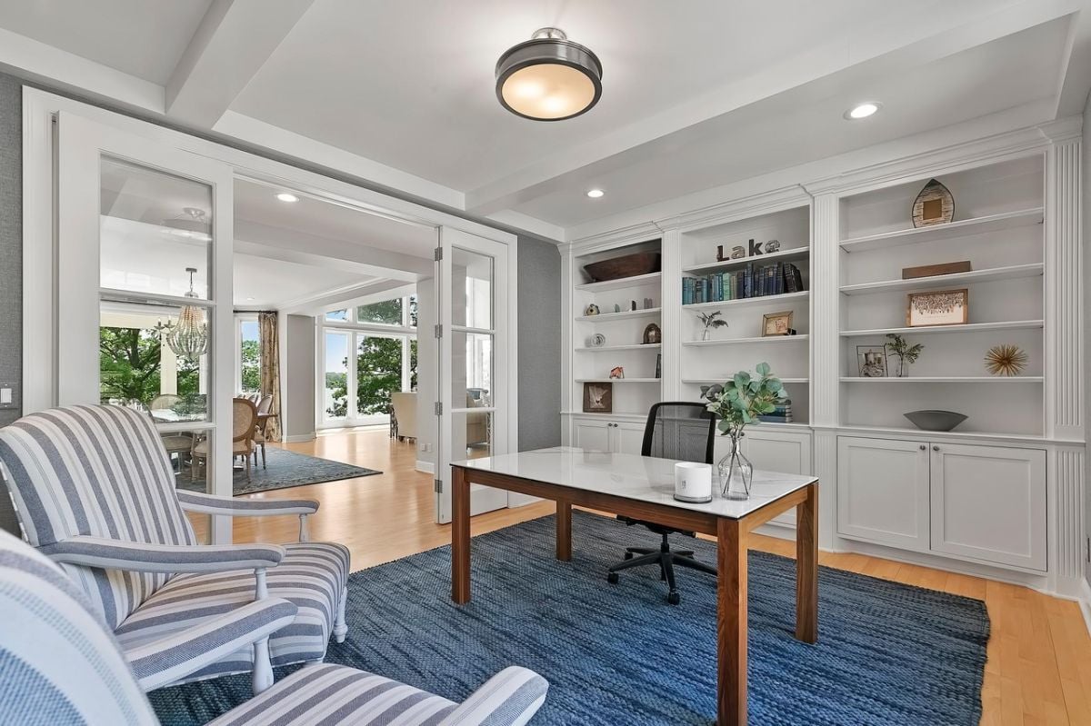 Home office with custom lighting, shelves, and cabinets.