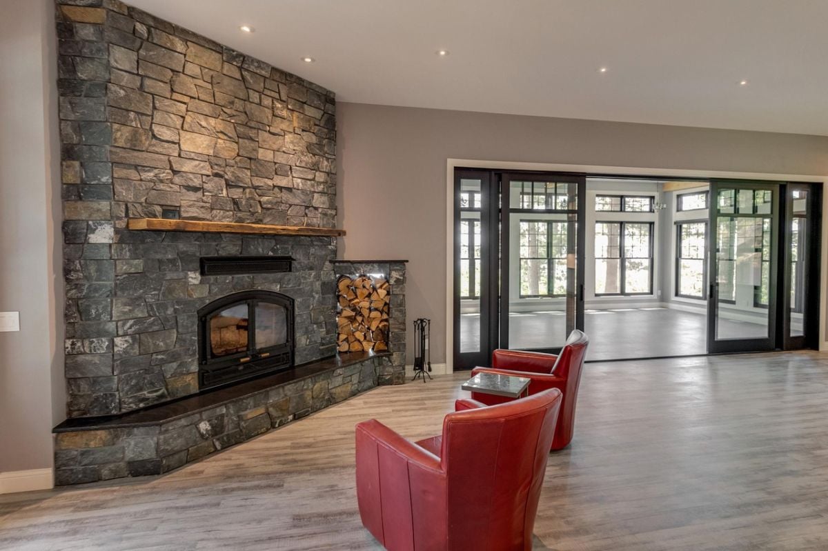 Living room with a fireplace, wood flooring, and custom lighting.
