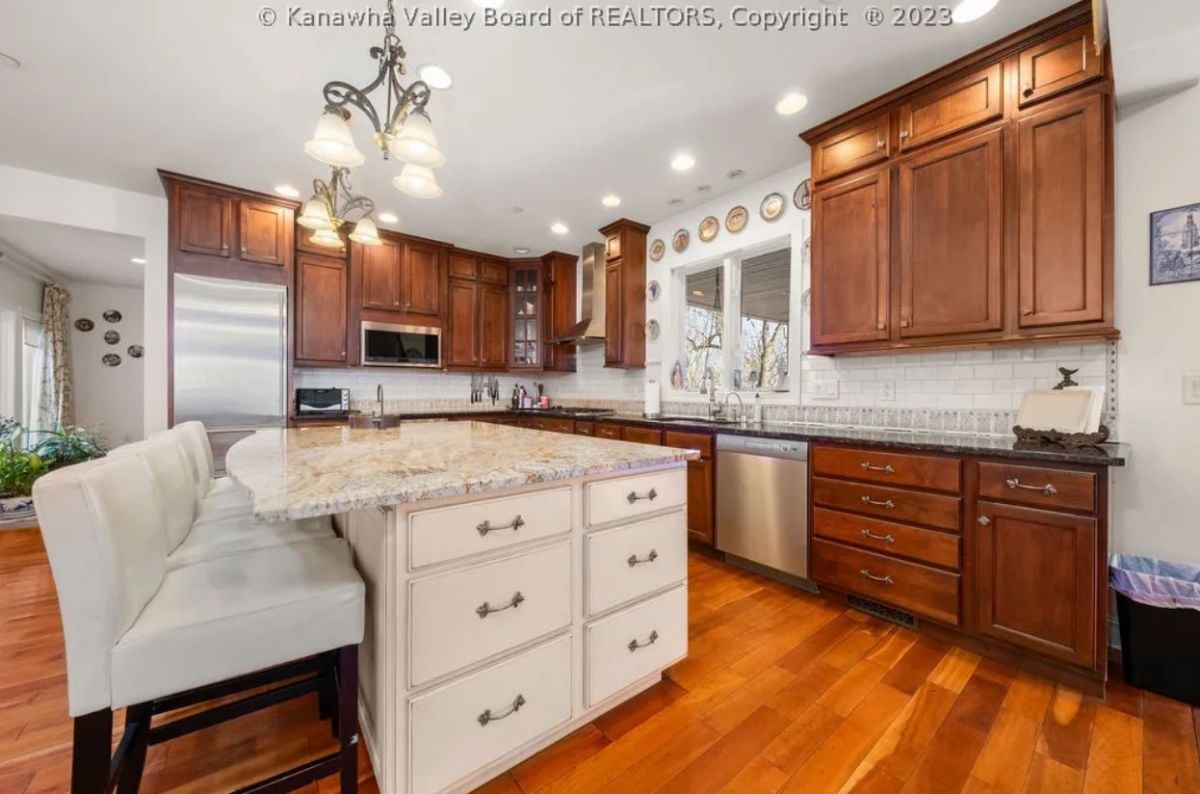 Kitchen with wood flooring, custom lighting and custom cabinetry.