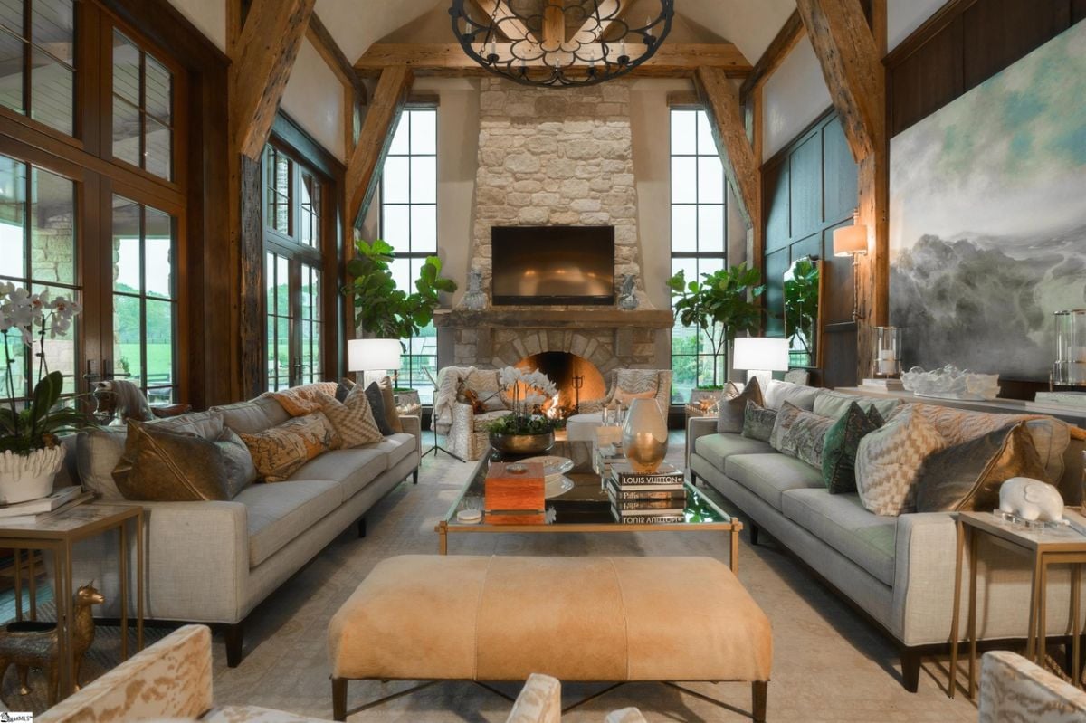 Living room with couches, a fireplace and glass windows.