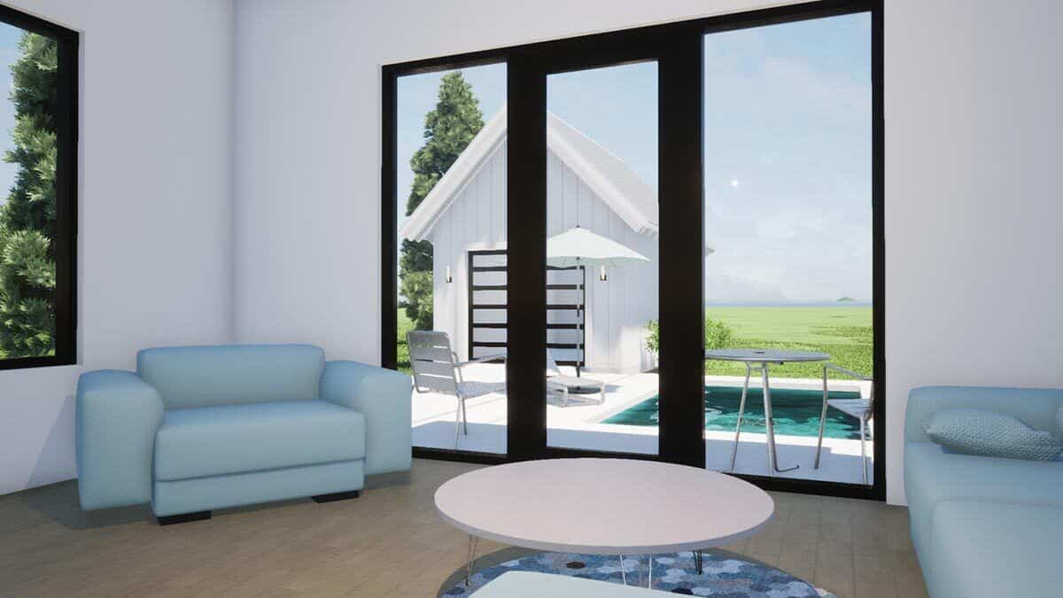 Family room with light blue sodas, a round coffee table, and a glazed door that opens onto the pool deck.