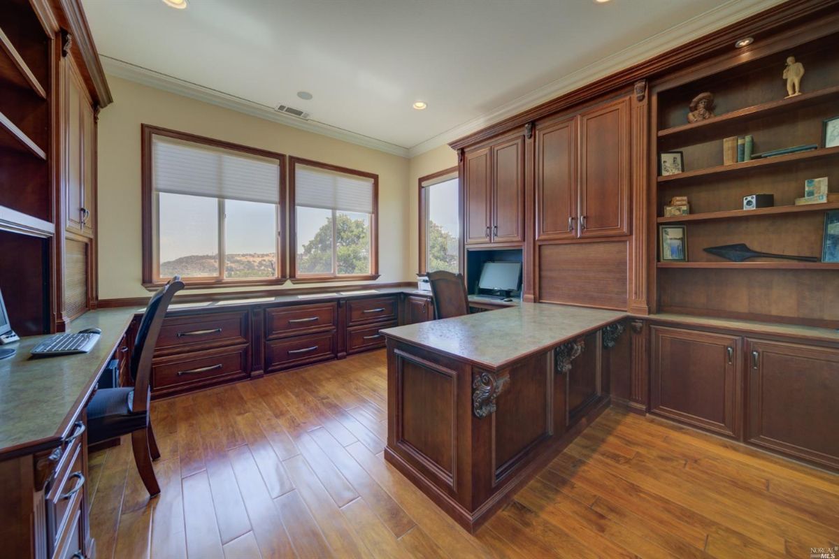Home office with a desk, computer, and cabinets.