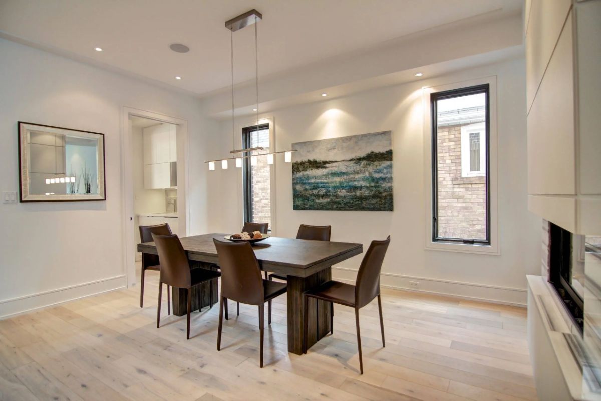 Dining room with custom lighting, a table and chairs.