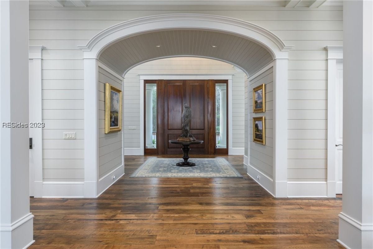 Large foyer with a wooden floor and white walls.