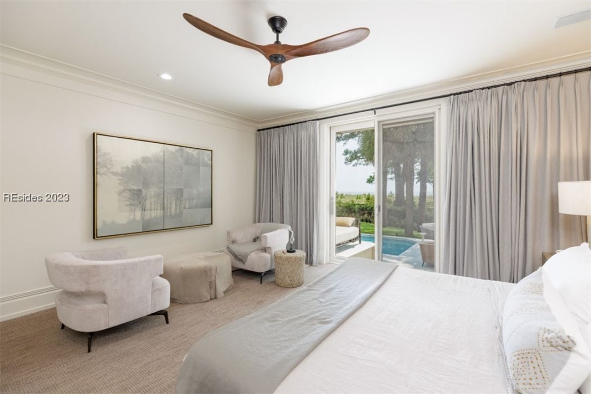 Bedroom with carpet flooring, couches, and sliding glass doors.