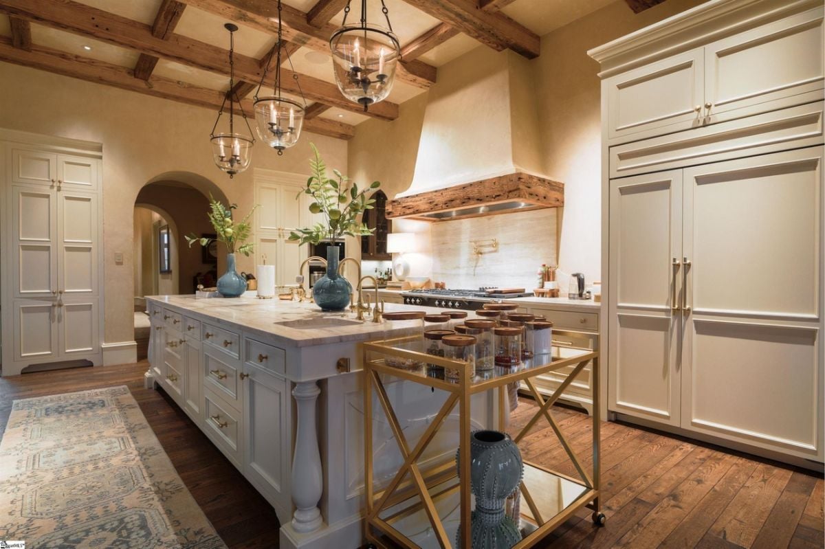 Kitchen with a large island, custom lighting and custom cabinetry.