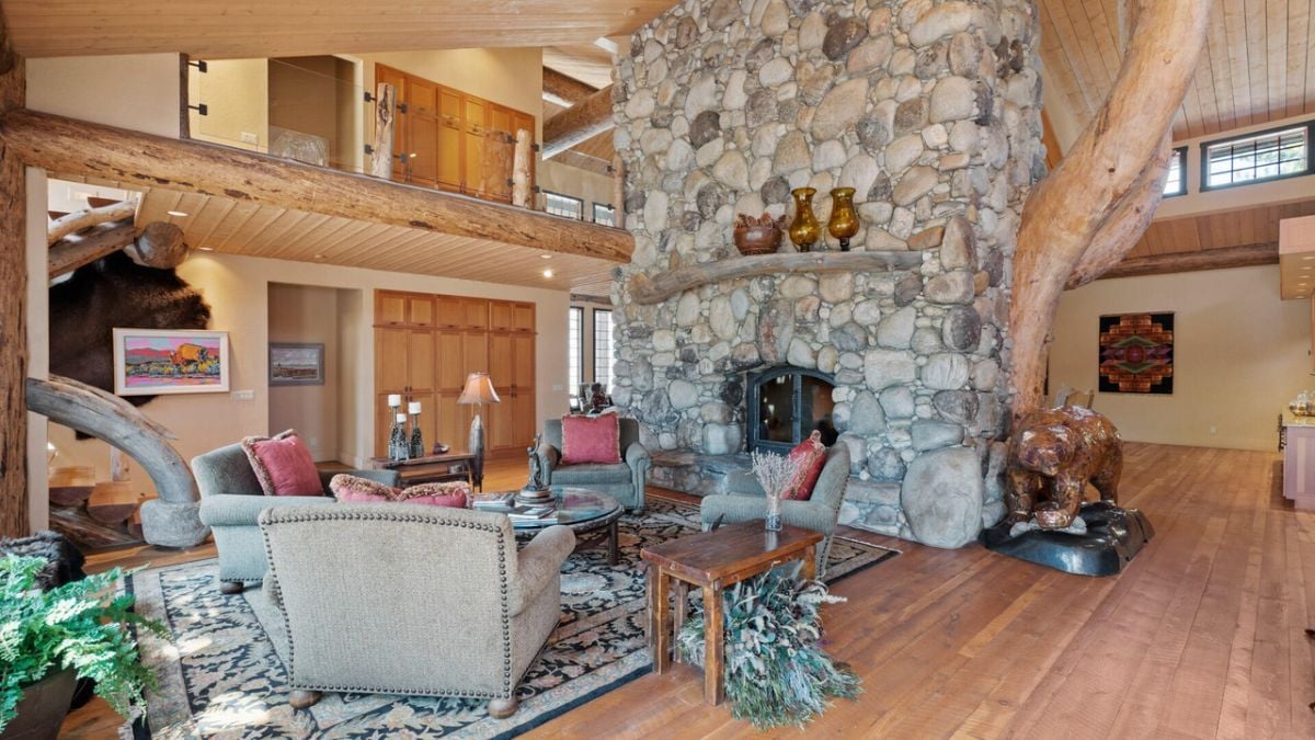 Living room with couches, wood flooring and a fireplace.