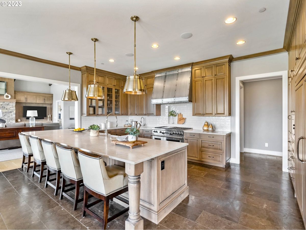 Kitchen with a large island, custom lighting, and custom cabinetry.