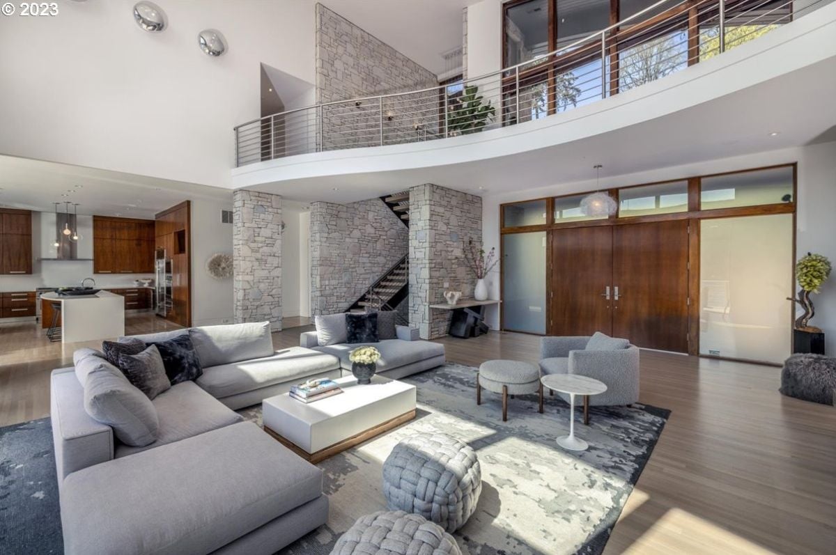 Living room with couches, wood flooring, and high ceilings..