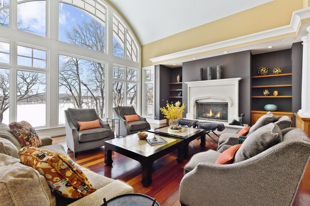 Living room with couches, a fireplace and a large glass windows.