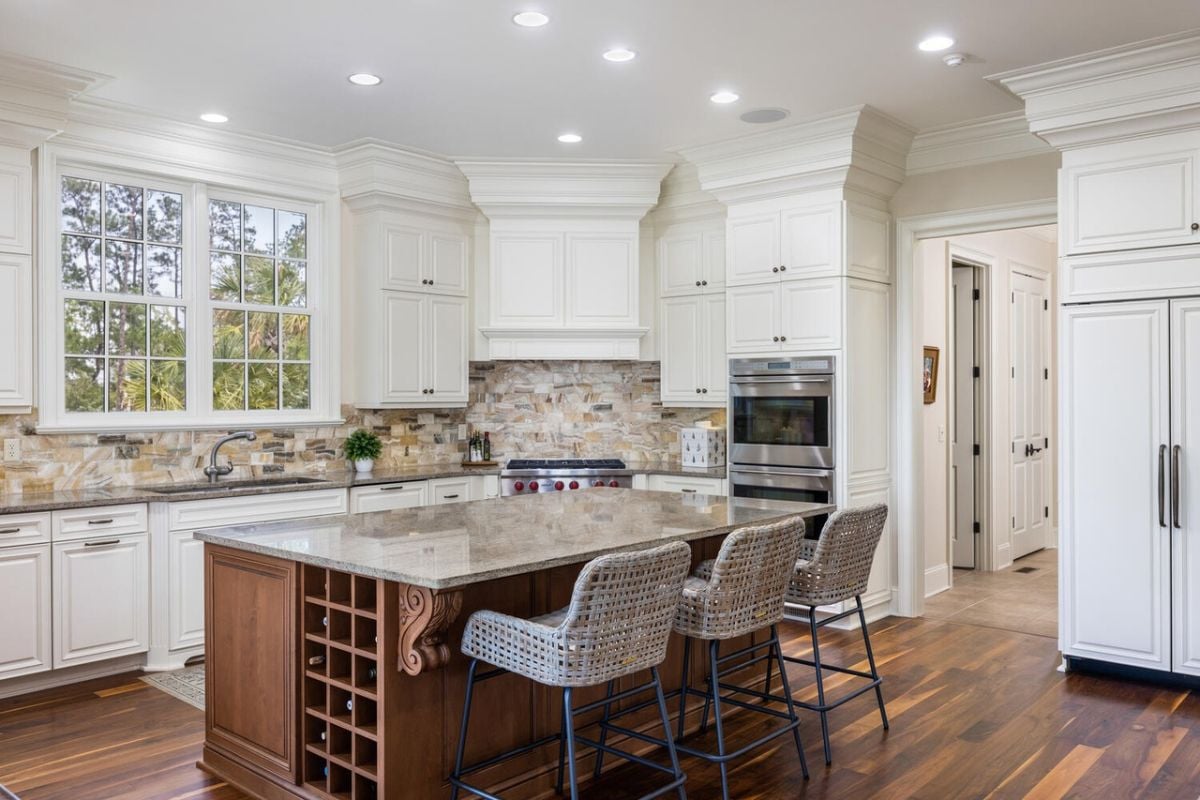 Kitchen with white cabinets, custom lighting, and a large island.