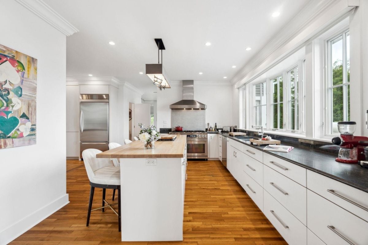 Kitchen with custom cabinetry, wood flooring, and custom lighting.