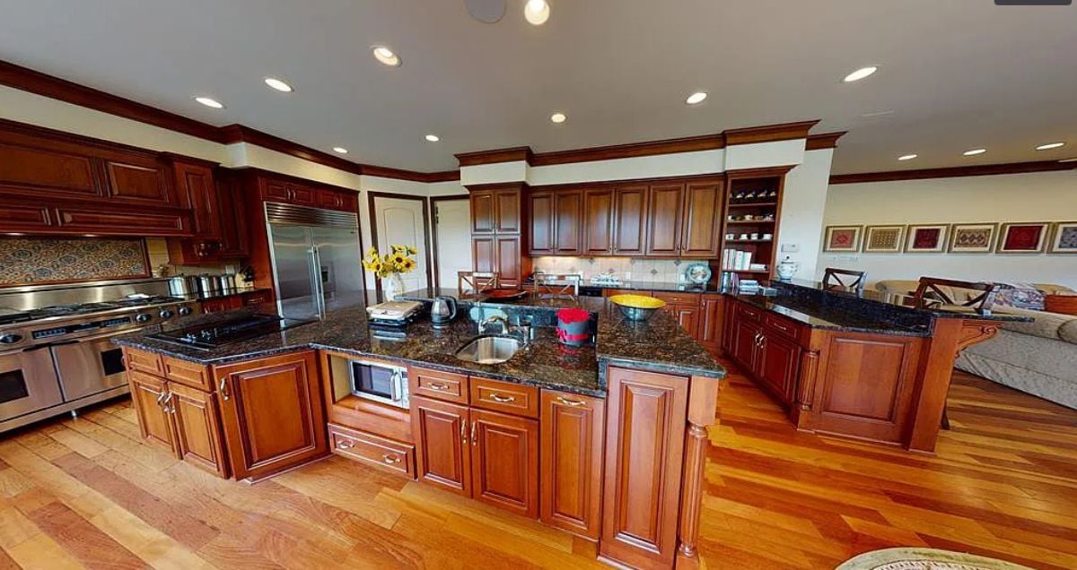 Kitchen with custom lighting, wooden cabinets and granite counter tops.