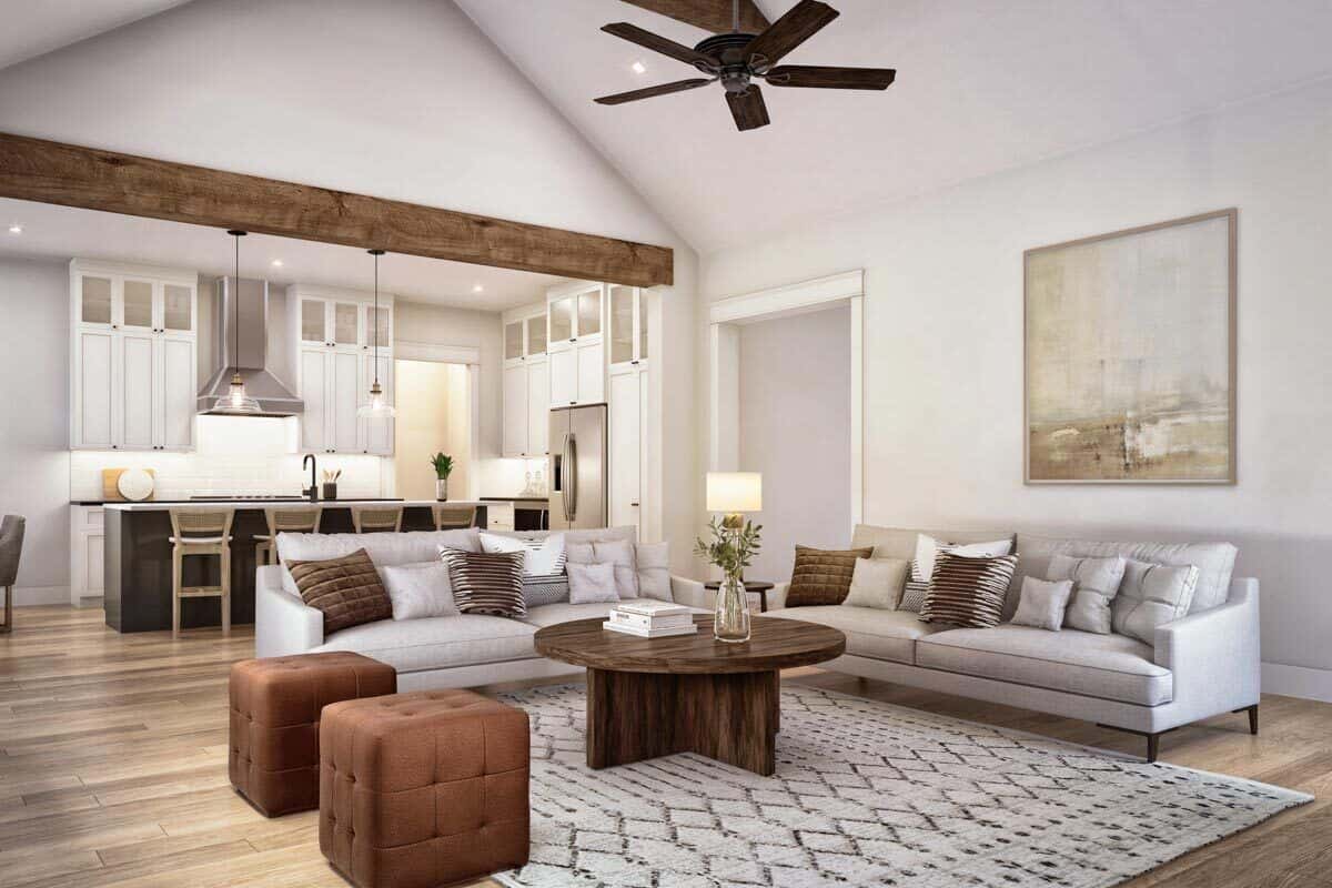 Great room with gray sofas, tufted ottomans, and a wooden coffee table under a cathedral ceiling.