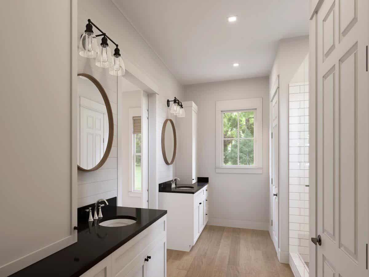 Primary bathroom with a water closet, a walk-in shower, and his and her vanities topped with white cabinets and round mirrors.