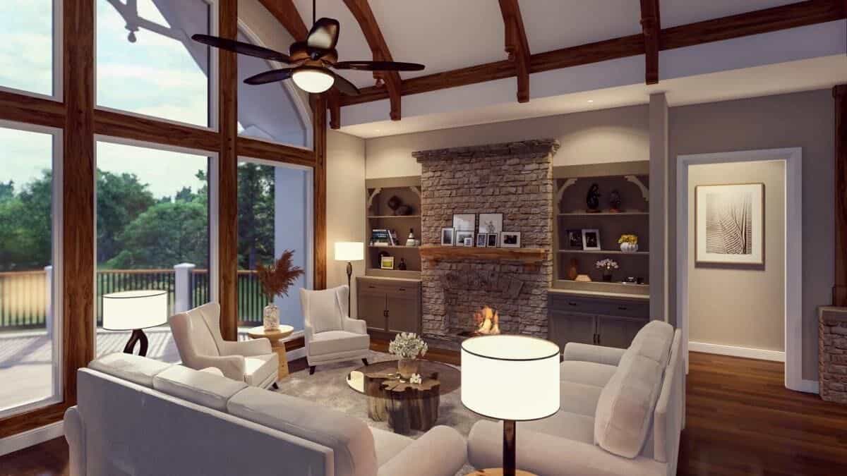 Lodge room with beige seats, a stone fireplace, and a cathedral ceiling framed with exposed trusses.