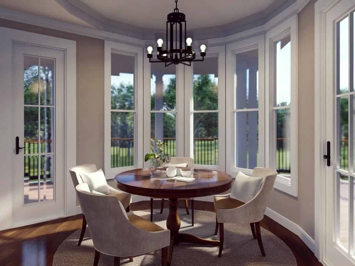 Breakfast nook with a round dining set and a bow window that looks out the covered porch.