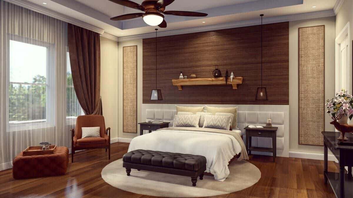 Primary bedroom with a tray ceiling, a cushioned armchair, and a custom bed complemented with a tufted bench.