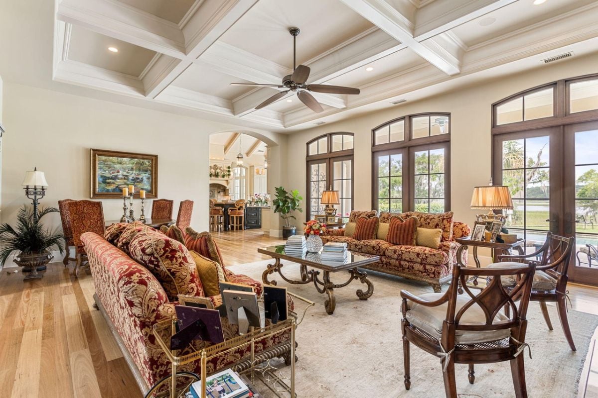 Living room with beamed ceilings, couches, and custom lighting.