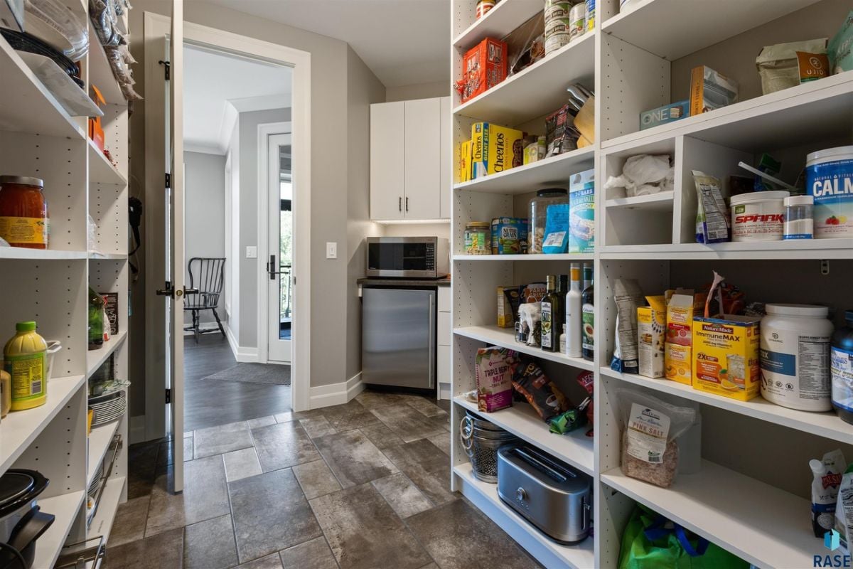 Pantry with white cabinets and shelves.