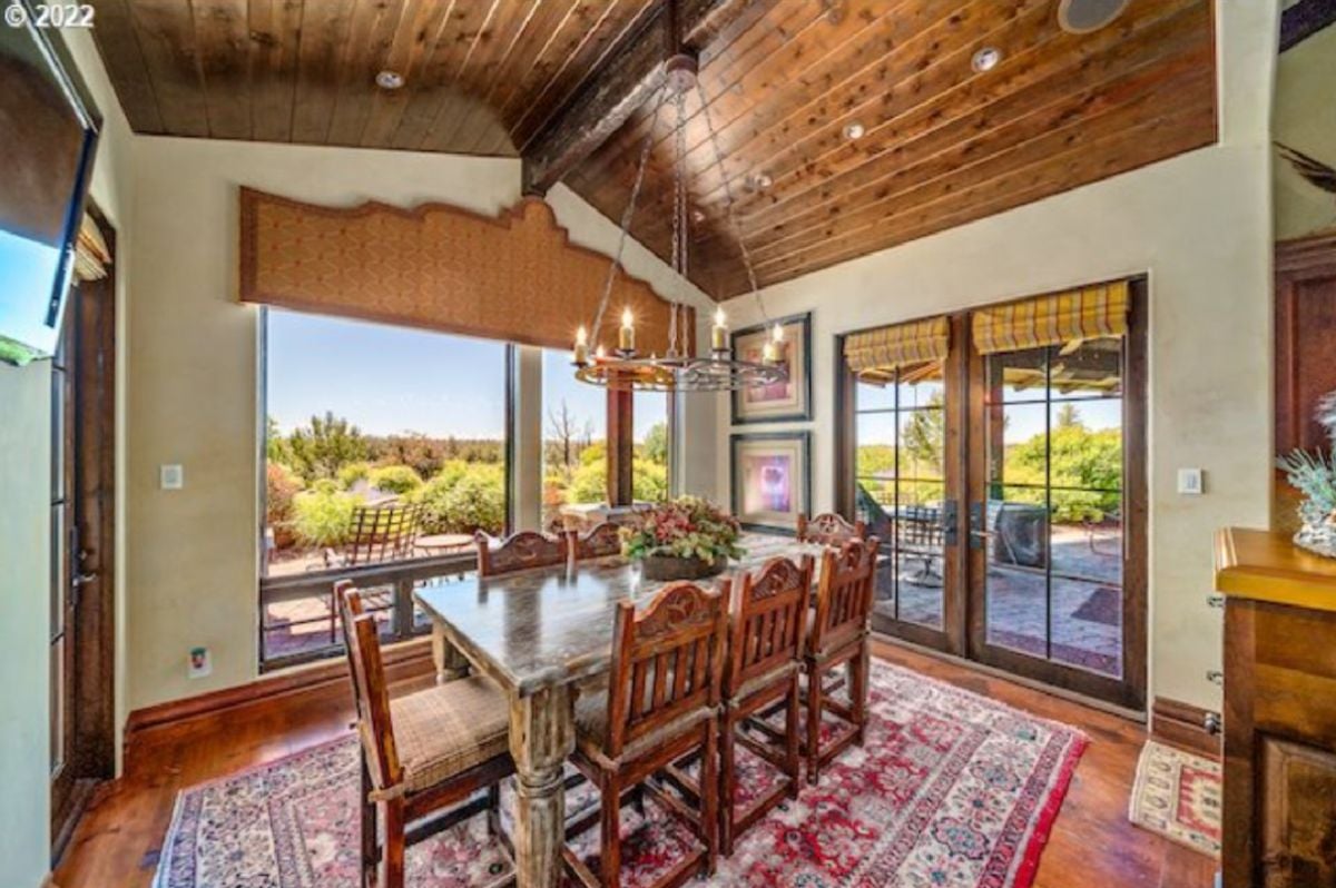 Breakfast area with a chandelier, glass windows, and glass doors.