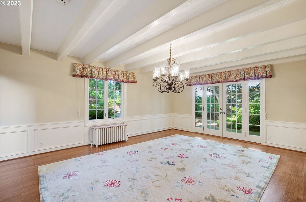 Bedroom with wood flooring, chandelier, glass windows and glass doors.