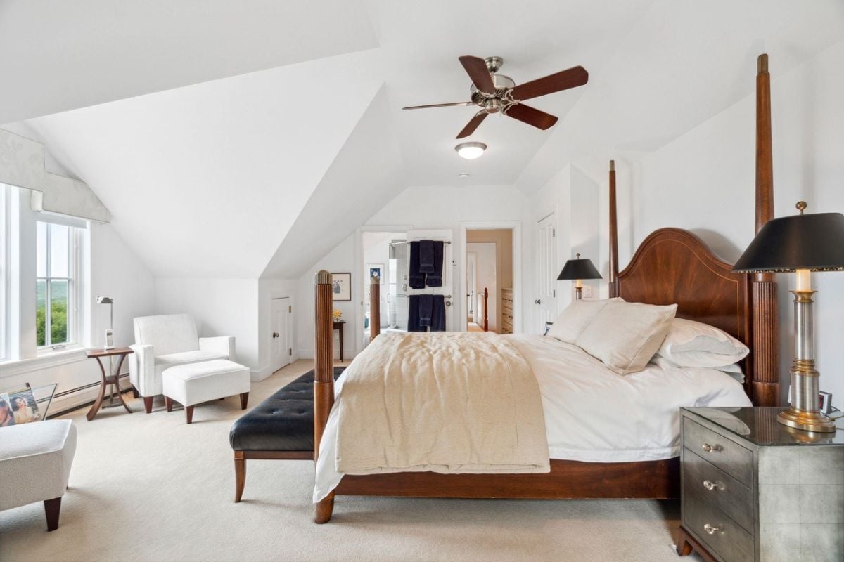 Bedroom with carpet flooring, a large bed, and glass windows.
