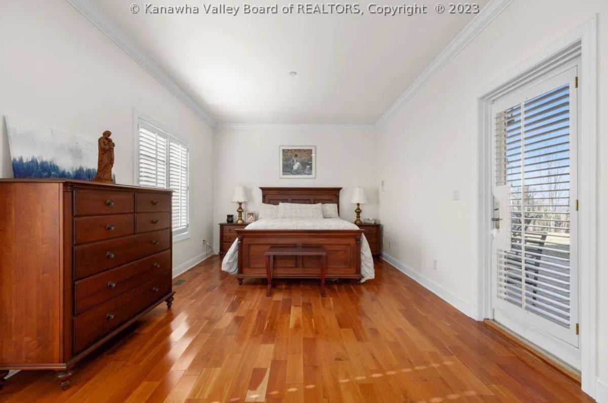 Bedroom with wood flooring, a drawer and glass door.