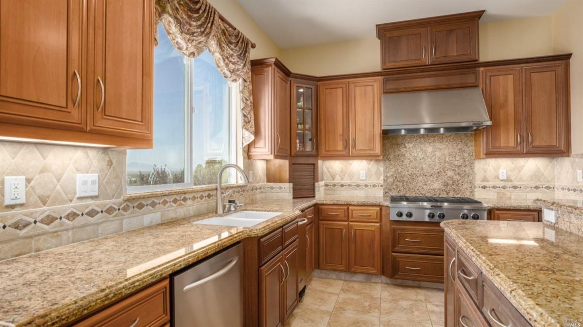 Kitchen with a sink, granite countertops, and custom cabinets.