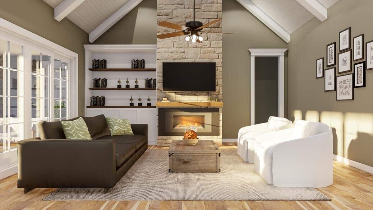 Great room with a leather sofa, white armchairs, and a stone fireplace under a cathedral ceiling.