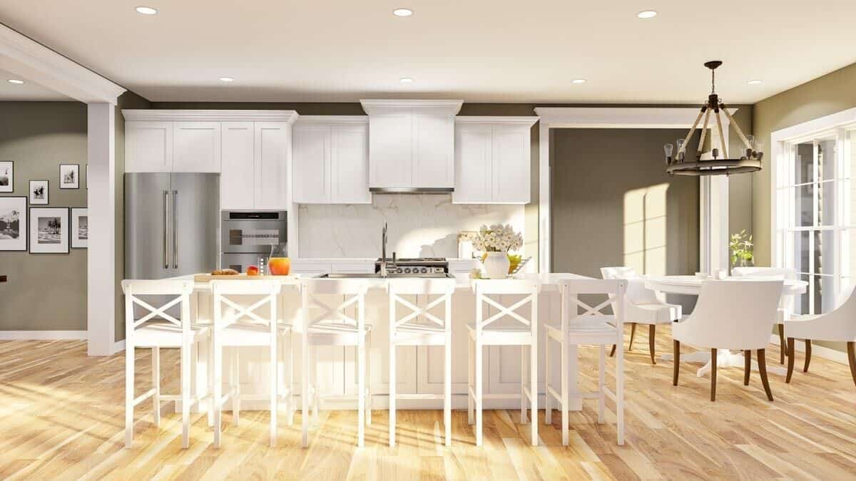 Kitchen with white cabinets and a breakfast island paired with matching counter chairs.