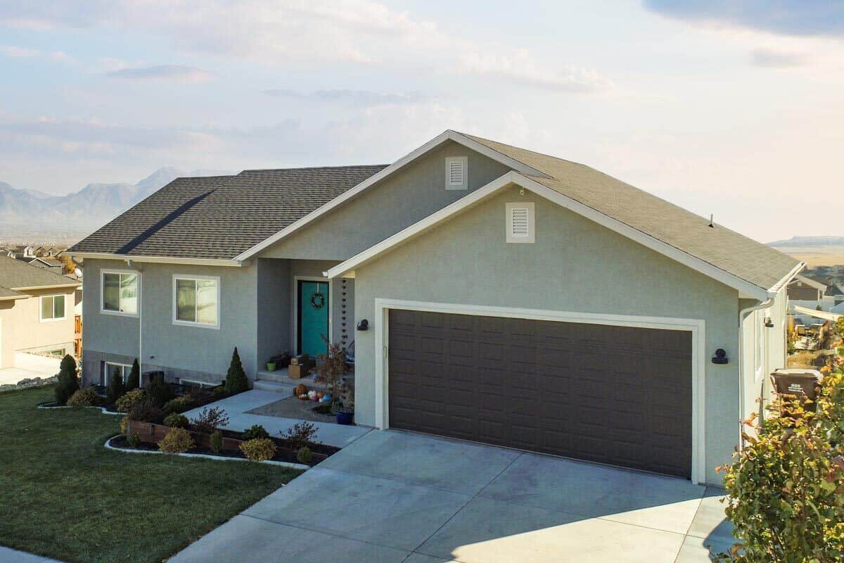 Front-right view with a double front-loading garage and a concrete driveway.