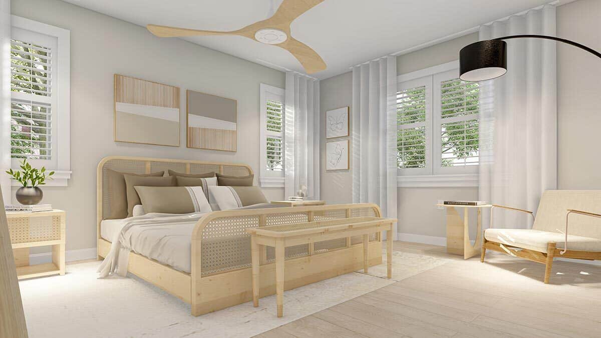 The primary bedroom includes a cushioned armchair and louvered windows bringing natural light in.