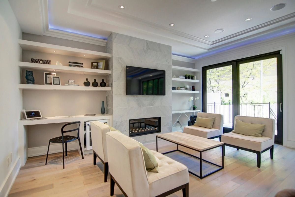 Media room with couches, a large TV, and a fireplace