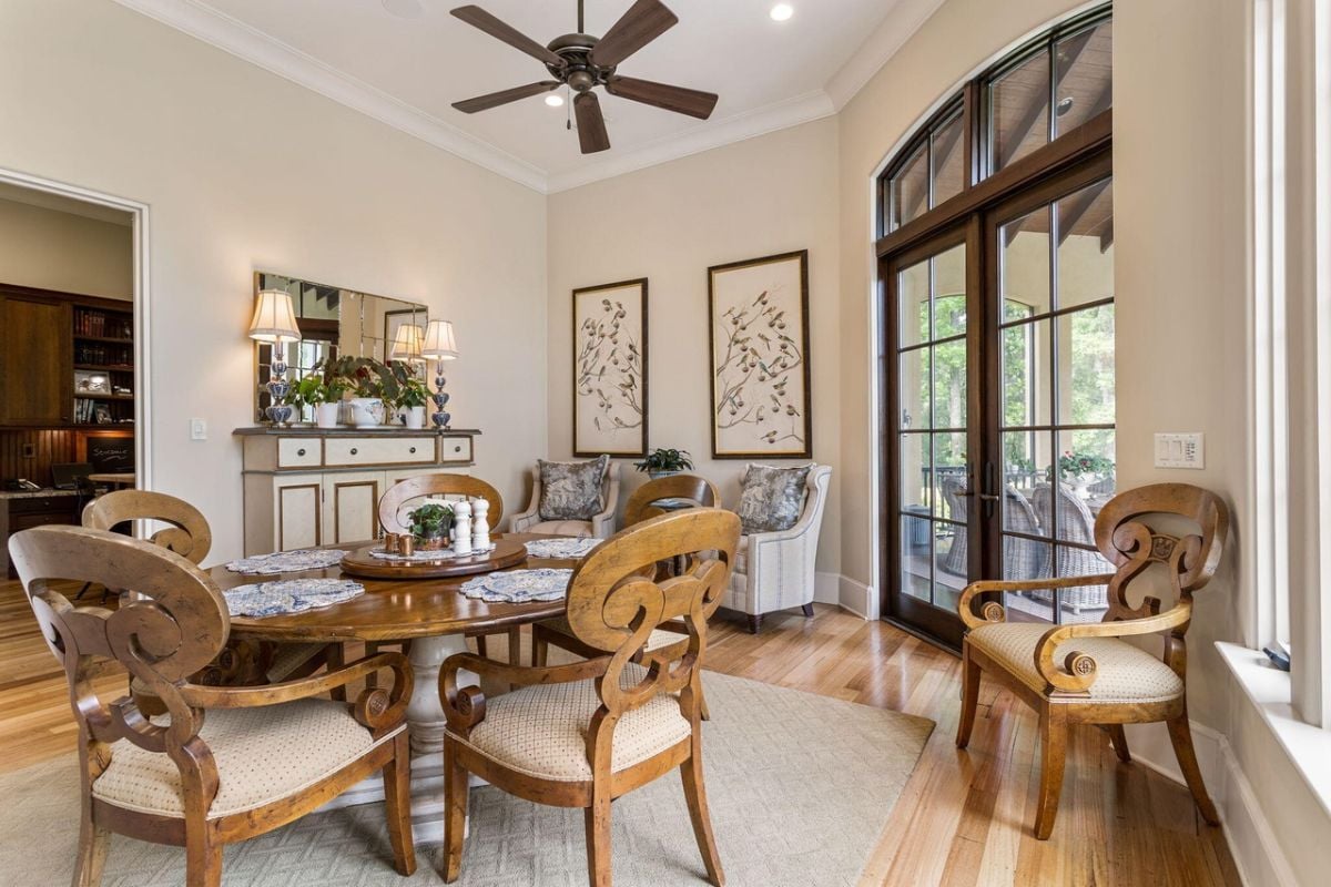 Breakfast area with a ceiling fan, custom lighting and glass doors.