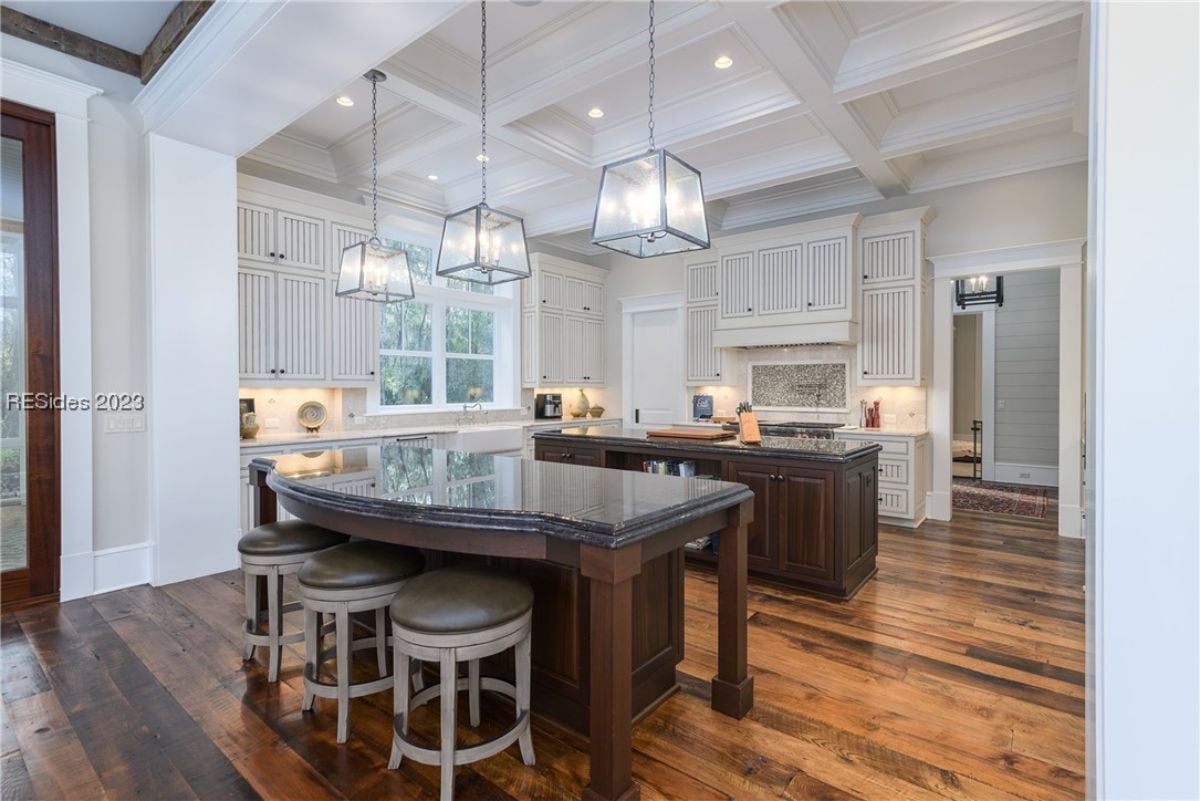 Kitchen with custom lighting, wood flooring and custom cabinetry.