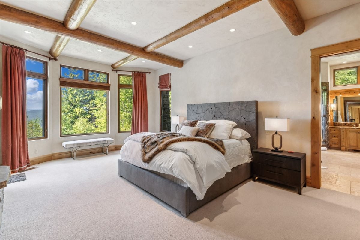 Bedroom with carpet flooring, glass windows, and a large bed.