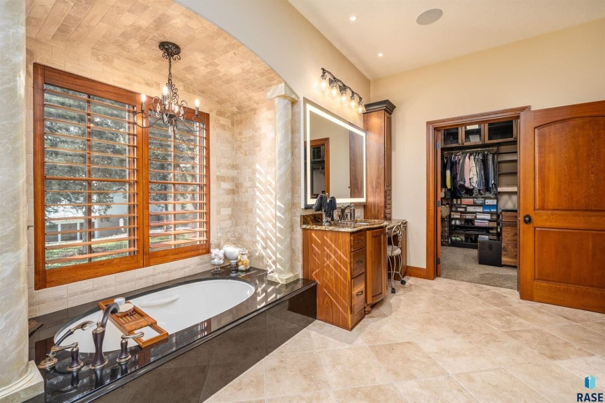 Bathroom with a bath tub, tile flooring, and a sink.