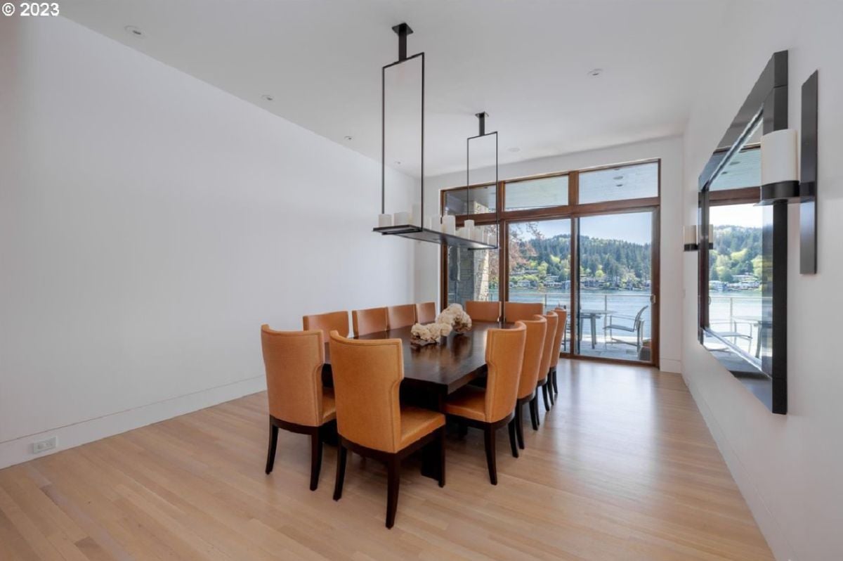 Dining room with wood flooring, large glass doors, and a view of the lake.