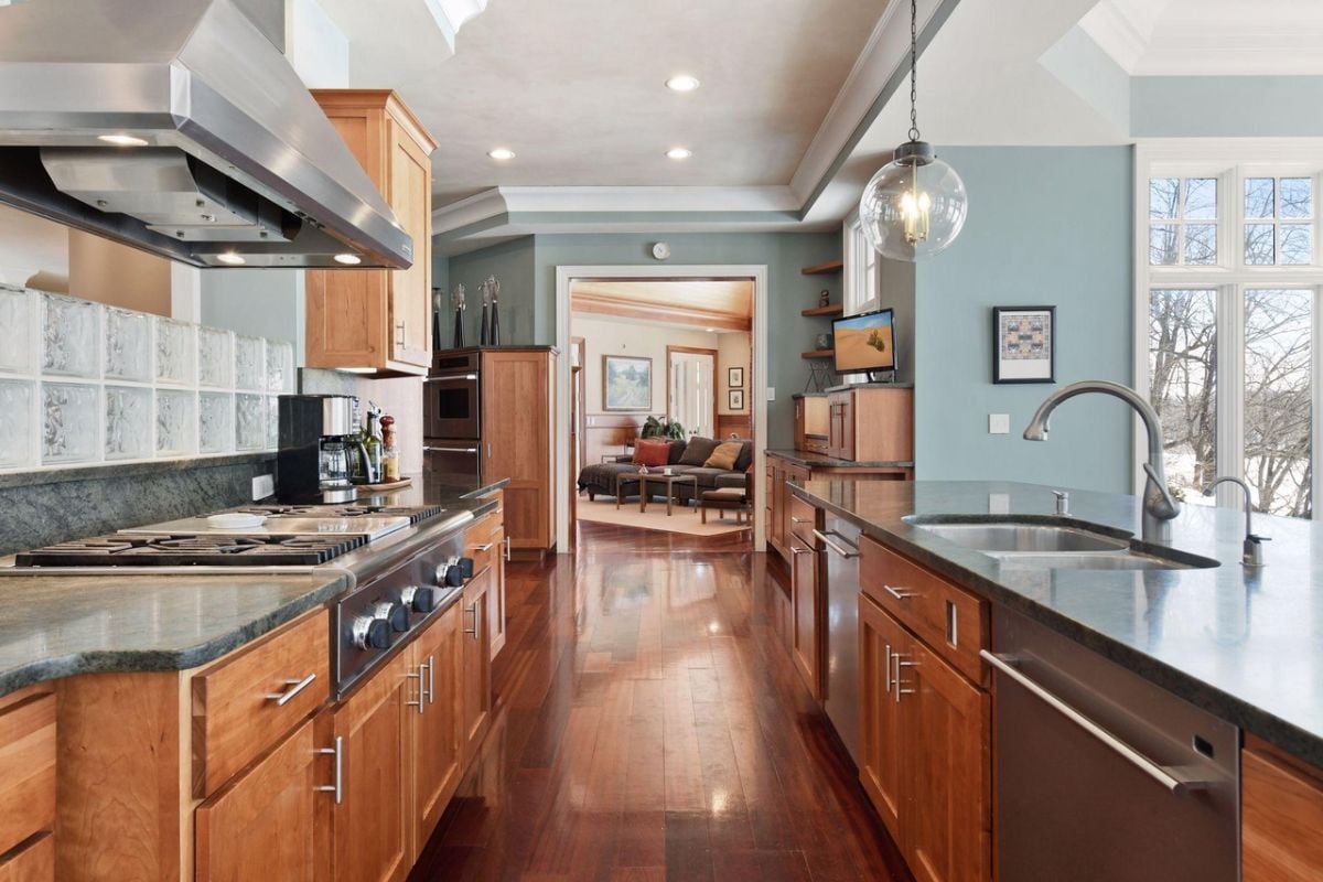 Kitchen with a large center island, custom cabinetry, and custom lighting.