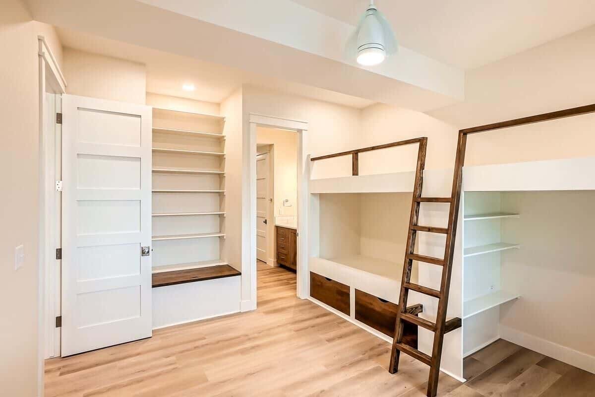Secondary bedroom with built-in shelves and a custom bunk bed incorporated with additional storage.