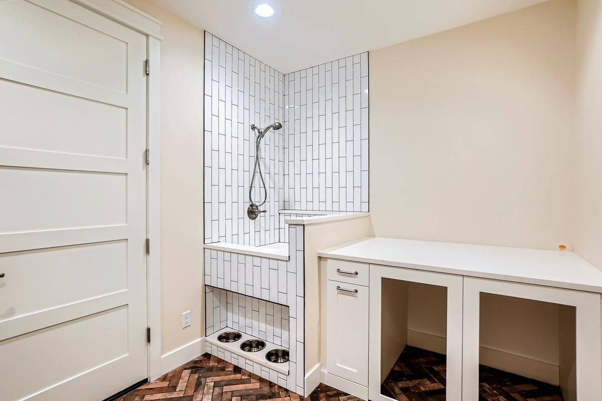 Utility room with a shower, a countertop, and parquet flooring.