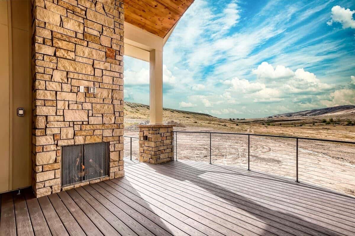 The rear deck includes a stone fireplace and sweeping views of the surrounding landscape.