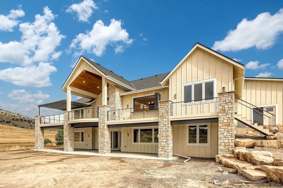 Rear-left view of the house with an expansive deck supported by stone columns.