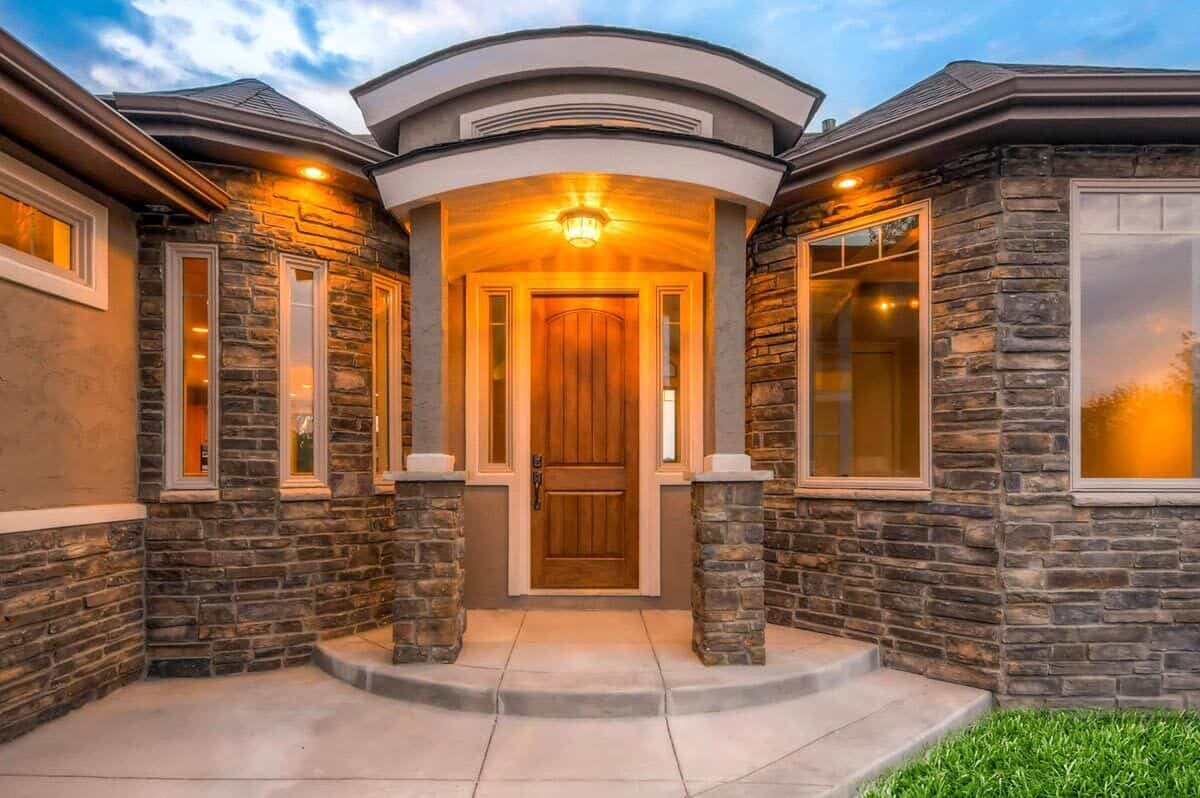 Front entry with stone base columns and a wooden front door.