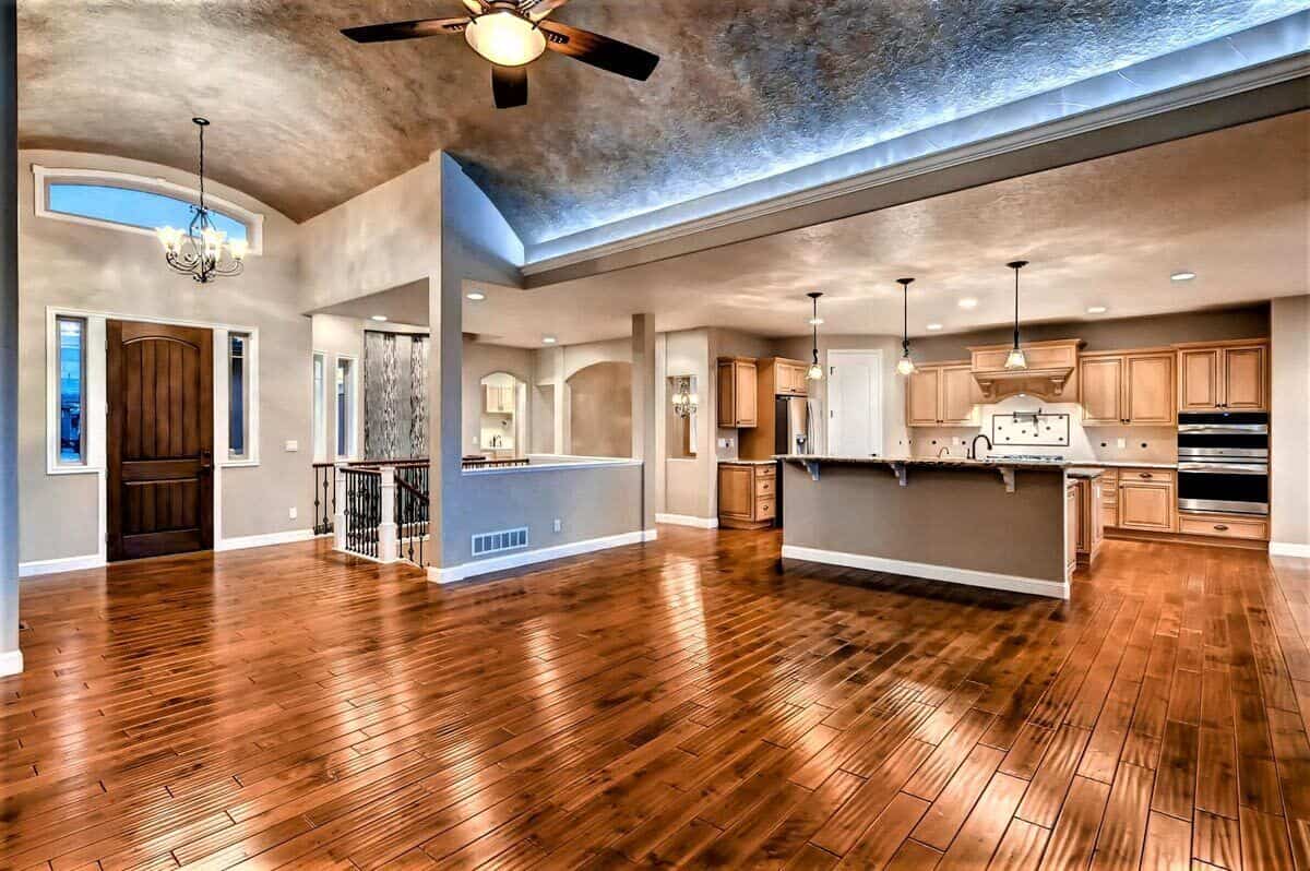 Great room and kitchen with hardwood flooring and gray walls.